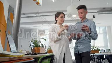 两位年轻的企业家在办公室里看报纸
