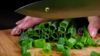 在木切板上切绿色新鲜洋葱。 快关门。