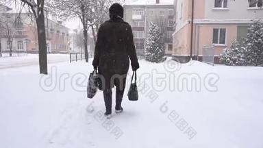 一个女人拿着<strong>袋子</strong>在一个下雪的城市里买东西，这是雪，冬天。 <strong>新年</strong>礼物，慢动作
