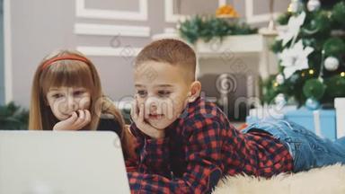 快乐的孩子们正在装饰<strong>新年</strong>的房间里用笔记本电脑玩现代有趣的<strong>游戏</strong>。