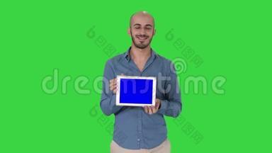 阿拉伯男人走着，展示平板电脑，在绿色屏幕上展示一些东西，Chroma键。