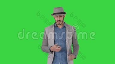 <strong>时尚</strong>、<strong>时尚</strong>、积极、开朗的<strong>男士</strong>穿着休闲衬衫，戴着遮阳帽，在绿色屏幕上与摄像机交谈