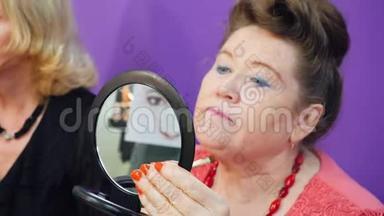 老年妇女照镜子，用化妆刷化妆