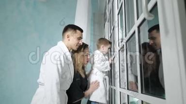 年轻的一家人正<strong>看着窗外</strong>有趣的东西。