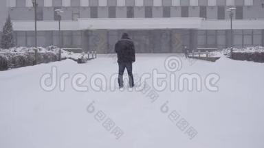 城里的一个人正在雪地里慢悠悠地走在街上