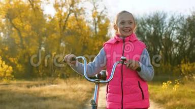 孩子们在公园里骑自行车旅行。 年轻女孩走路。 一个年轻女孩沿着<strong>马路</strong>散步，骑自行车