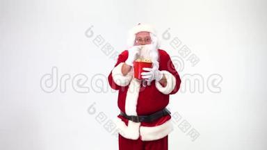 圣诞节。 白色背景上的圣诞老人，带着一个带爆米花的红色桶。 有爆米花，看电影，情绪