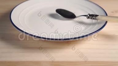 一个白色的盘子，上面有蓝色的<strong>条纹</strong>，上面有一个甜点勺子