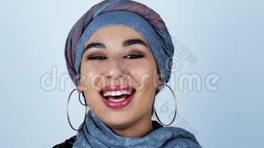 年轻美丽的阿拉伯女人在孤独的白色背景上感<strong>受到</strong>快乐的微笑