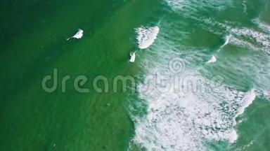 鸟瞰碧绿色的海浪向岸边滚动。 <strong>无法识别</strong>的冲浪者试图兑现完美的海浪