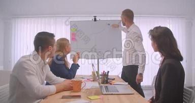 四个欢快的拼贴画在办公室室内开会。 商人在白板上画一张图表