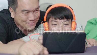 <strong>父亲和儿子在家里</strong>带着笑脸<strong>在</strong>平板电脑上欣赏电影