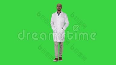 阿拉伯英俊的医生穿着制服，双手插在绿色屏幕上的口袋里，Chroma键。