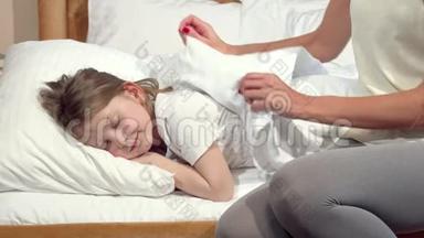 一个面目全非的女人为她熟睡的小女儿捏着毯子
