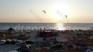 在海滩露营，人们在海上玩风筝、日落、空中射击