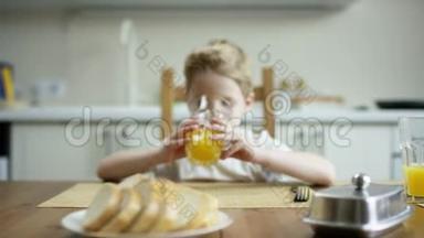 一个<strong>可爱</strong>的男孩拿着一杯橙汁坐在桌旁，等着另一家人吃一顿<strong>超</strong>量照相机