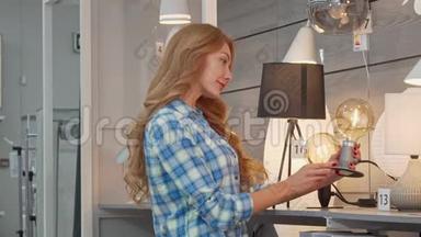 漂亮的女人在家具店为她的公寓买灯饰