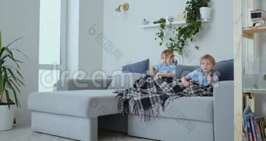 两个男孩，4岁和2岁，坐在沙发上看电视。 令人兴奋的<strong>电视节目</strong>。 看<strong>动画</strong>片。 孩子们看着