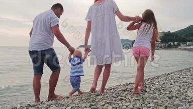 <strong>一家人</strong>慢慢地去海滩。 宝贝`在<strong>海边</strong>的第一步。