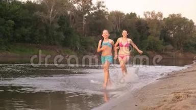快乐的孩子们沿着海滩奔跑。 女孩们在沙滩上奔跑，在海滩上<strong>溅起水</strong>滴，笑着。 快乐和快乐