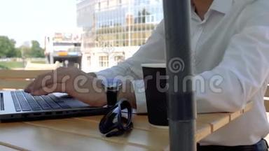 一个穿着白色衬衫，坐在街边咖啡馆里用手提<strong>电脑</strong>键盘<strong>打字</strong>的男人的双手紧闭。 商人<strong>打字</strong>