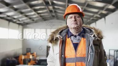 戴着安全帽、穿着工作服的人正站在机库的中间，带着责备的目光看着摄像机