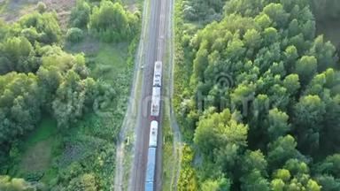 日落时在夏季松林上<strong>行驶</strong>的郊区<strong>火车</strong>通勤铁路的鸟瞰图。 无人驾驶飞机的4k段录像