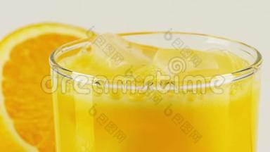 碳酸橙软饮料加冰在玻璃杯中，特写慢镜头红