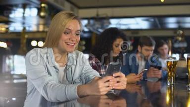 在酒吧使用手机、在约会应用程序中阅读信息、免费无线上网的年轻人