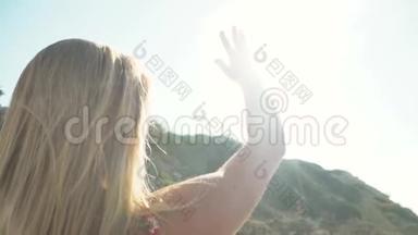 在<strong>阳光</strong>明媚的天气里，年轻快乐的女孩用手在美丽的岛屿上的海滩上遮住<strong>阳光</strong>