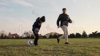 快乐的儿子和爸爸在操场上奔跑，一个接一个慢动作<strong>踢</strong>足球的特写镜头