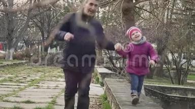 在<strong>城市</strong>公园里，小女孩和她的祖父一起沿着栏杆走着，环顾四周，微笑着<strong>看镜头</strong>