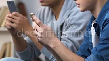 两名青少年在智能手机上玩快速电子游戏，手机游戏应用程序