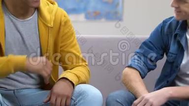 两个高中男生抱拳，坐在沙发上，友谊
