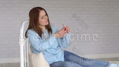 一位糖尿病妇女坐在家里的床上，用<strong>胰岛</strong>素注射器拨<strong>胰岛</strong>素。