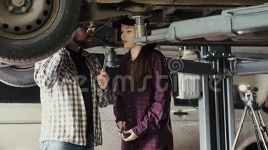 一个漂亮的女孩，一个汽车修理工，正在学习如何修理一辆汽车`一个更有经验的人，一个汽车悬架