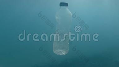塑料污染，塑料瓶在蓝色的水中。 废弃的塑料瓶在阳光下慢慢地漂浮在蓝色的水面下。