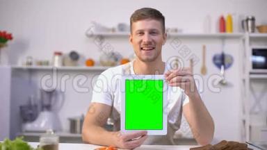 帅哥拿着绿色屏幕的平板电脑，烹饪课程申请