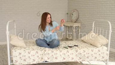 一位糖尿病妇女坐在家里的床上，用<strong>胰岛</strong>素注射器拨<strong>胰岛</strong>素。