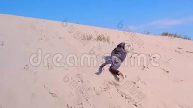 玩耍的小男孩在度假时在沙丘海滩上<strong>翻滚</strong>。