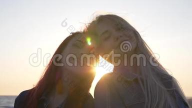 女朋友在夕阳的背景下微笑，风<strong>吹拂</strong>着她们的头发，阳光`阳光在她们的头间闪耀