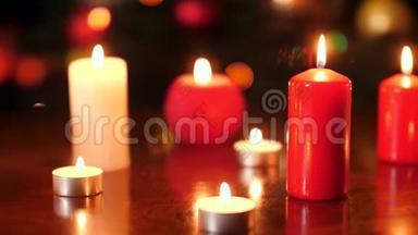 红色和白色燃烧蜡烛在夜间发光的彩色灯光下的4k视频。 完美的背景或背景