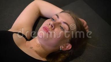 躺在<strong>卡</strong>里马特上的汗流浃背和疲惫的运动女孩在<strong>健身房</strong>里疲惫和疲惫的特写照片。