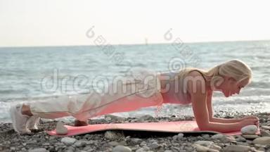 健身海滩女人微笑着做瑜伽练习。 快乐女孩训练腹肌锻炼核心肌肉