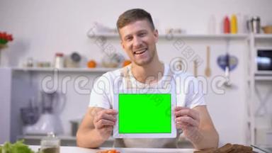拥有绿色屏幕平板电脑、烹饪博客和应用程序模板的开朗男人