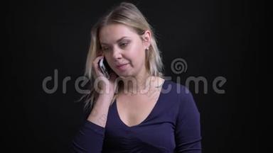 金发女商人穿着蓝色衬衫，带铲子领口，在黑色背景的智能<strong>手机</strong>上有非正式的<strong>语音</strong>信箱。