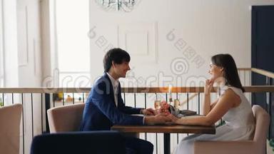帅哥在约会时和他的女朋友一起坐在桌子上，笑着享受浪漫的时刻
