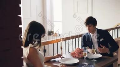 愤怒的年轻人正在和他沮丧的女朋友在漂亮的<strong>餐厅</strong>浪漫<strong>约会</strong>。 他在说话