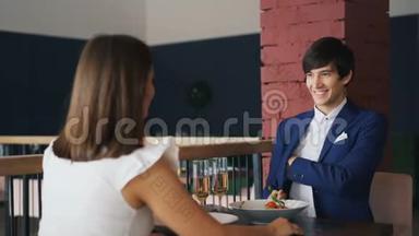 穿着漂亮西装的英俊小伙子正在漂亮的饭店里浪漫约会时向心爱的年轻女子求婚