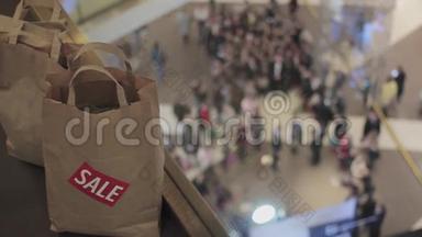 在黑色星期五，人们把带有销售标签的棕色袋子<strong>放在</strong>商场的<strong>地板</strong>上。 背景人群
